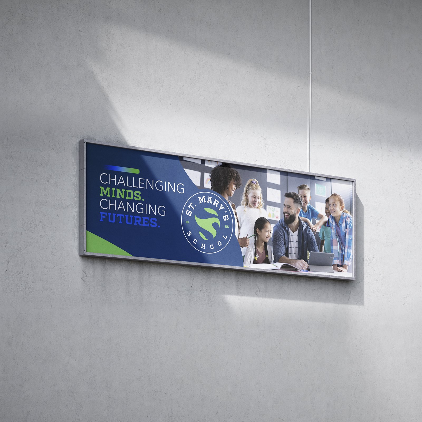 St. Mary’s School framed signboard mockup on a concrete wall carrying the Challenging Minds. Changing Futures. message